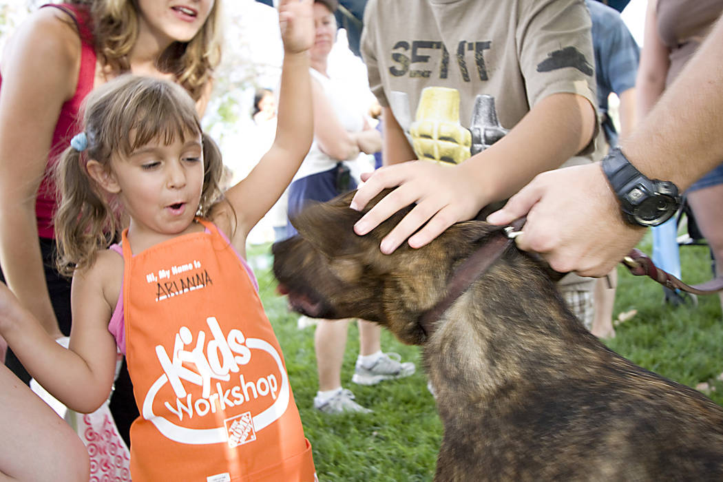 Arianna Falshi pulls her hand back when police dog Mato tried to lick her. Mato, a narcotics d ...