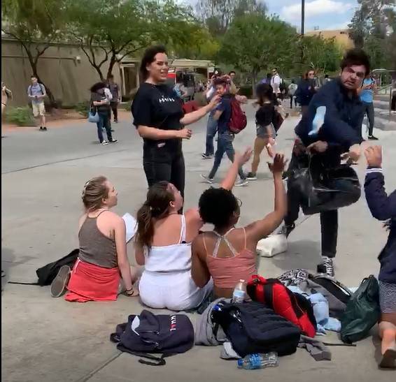 An unidentified male throws a granola bar at students working at a Turning Point USA booth at U ...