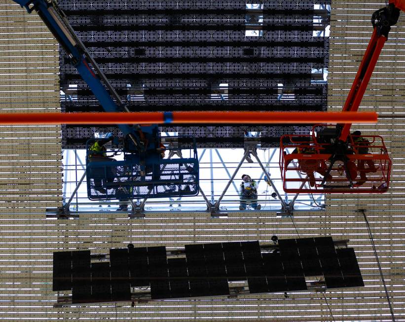 Construction workers install a new panel during the second day of renovations of the Viva Visio ...