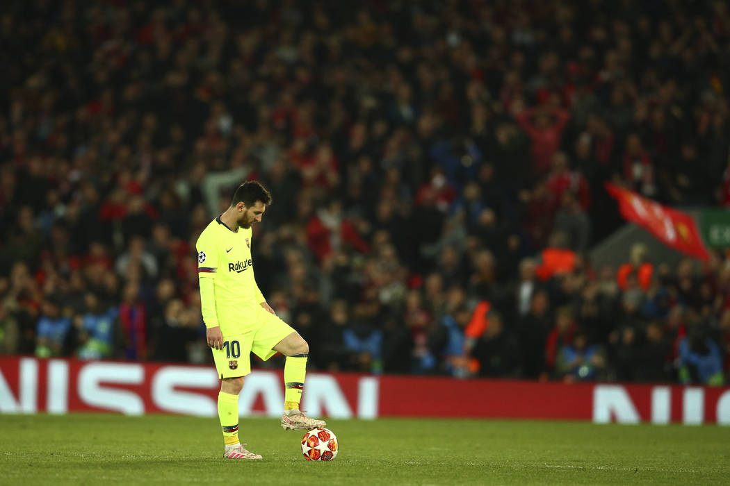 Barcelona's Lionel Messi keeps the ball as Liverpool's Divock Origi celebrates scoring his side ...