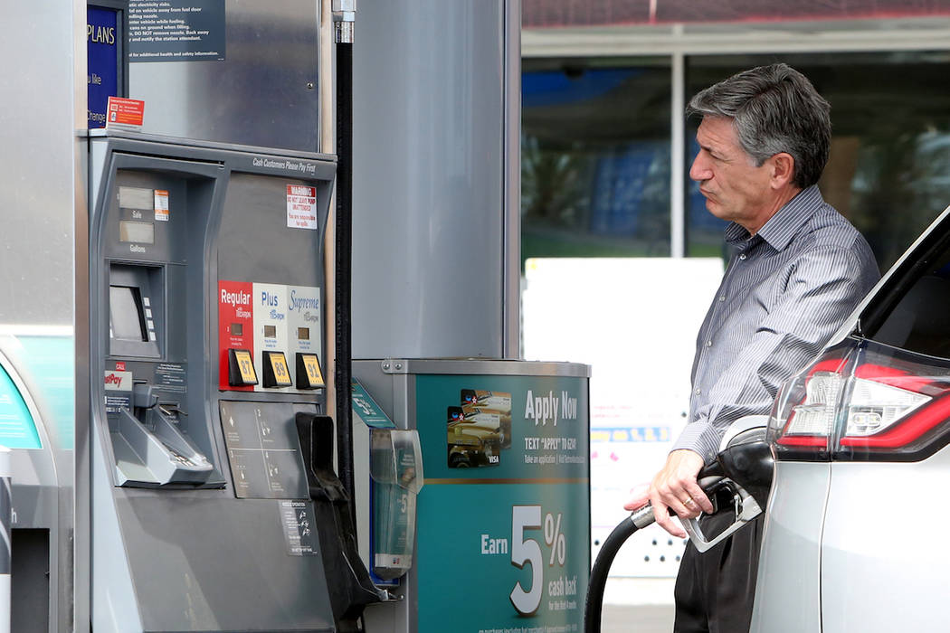 A customer pumps gas at Chevron gas station at the intersection of Tropical Avenue and Fort Apa ...