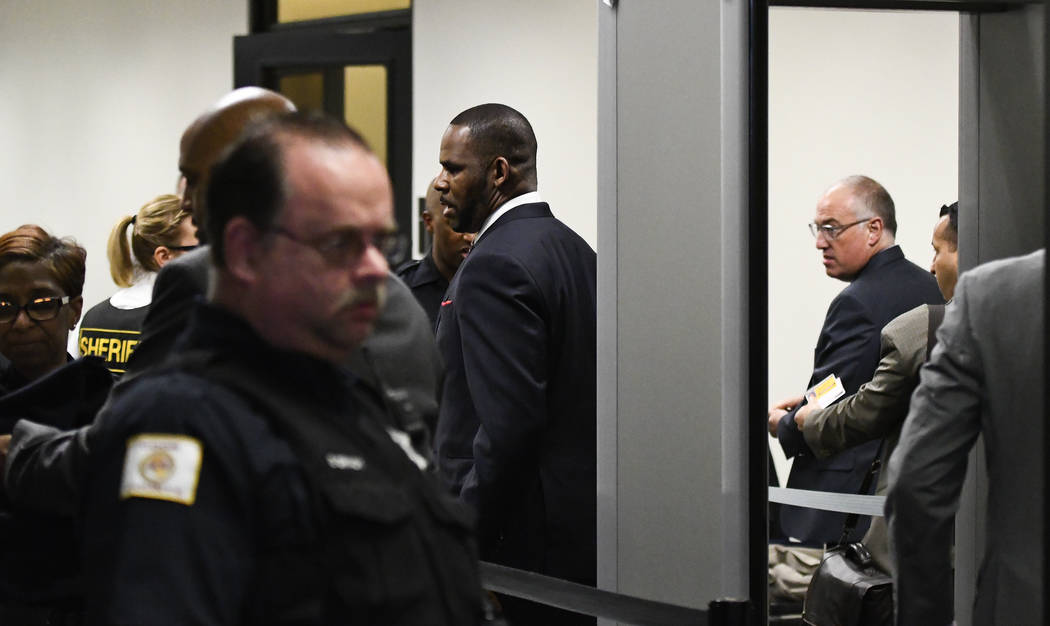 Musician R. Kelly, center, goes through security as he arrives at the Daley Center for a hearin ...