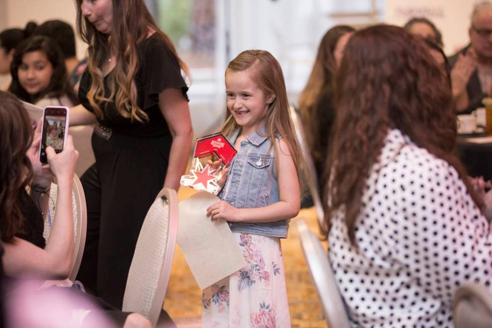 Award winner Sofia Frasier, middle, a first grader at Scherkenbach Elementary School, walks bac ...