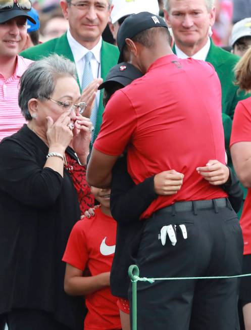 Tiger Woods' mother Kultida Woods wipes away tears as he hugs his daughter Sam and son Charlie ...