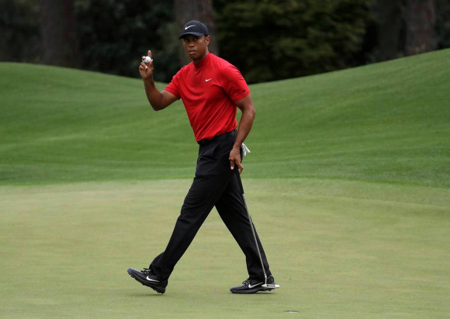 FILE - In this April 14, 2019, file photo, Tiger Woods waves on the eighth hole during the fina ...