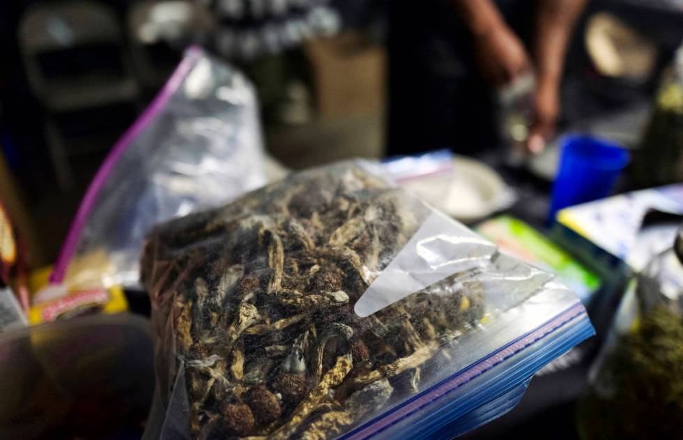 A vendor bags psilocybin mushrooms at a pop-up cannabis market in Los Angeles on Monday, May 6, ...