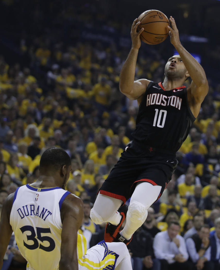 Houston Rockets' Eric Gordon, right, shoots over Golden State Warriors' Kevin Durant (35) durin ...