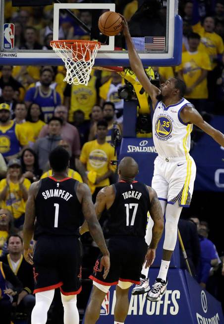 Golden State Warriors' Kevin Durant, right, scores over Houston Rockets' PJ Tucker (17) and Ima ...