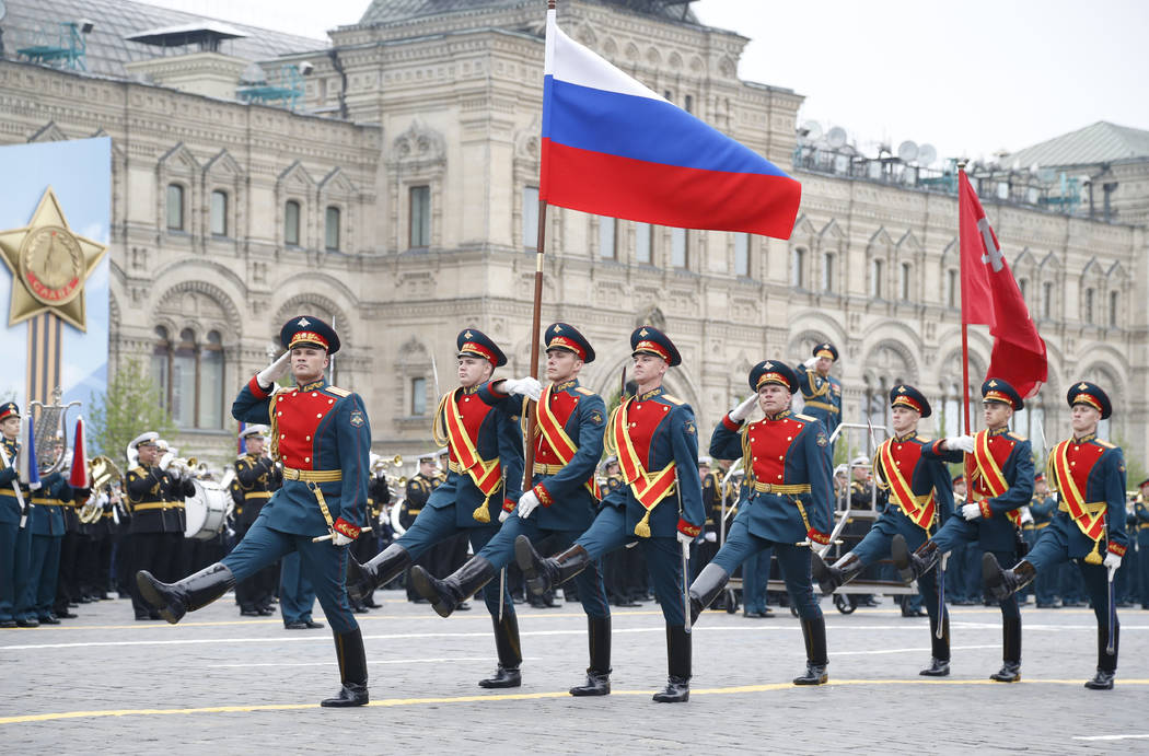 Russian honour guard carry a national flag, left, and a replica of the Victory banner during th ...