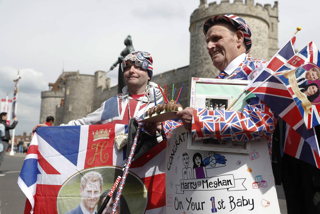Royal fans John Loughery, left and Terry Hutt pose with flags and banners, outside Windsor Cast ...