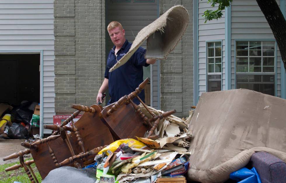 Jay Dabravio throws a matt onto a pile at the front of his house in the Sherwood Trail subdivis ...