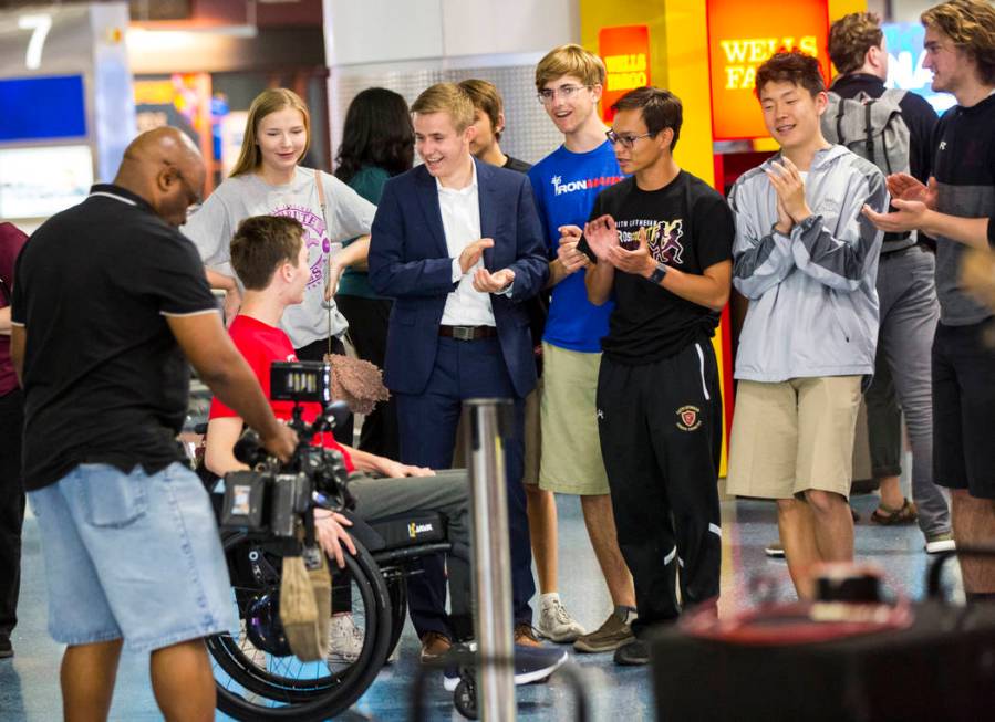 Friends cheer for Faith Lutheran senior Mark Wilbourne, in red, as he reacts to a welcome party ...