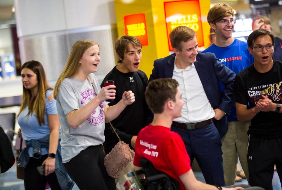 Friends cheer for Faith Lutheran senior Mark Wilbourne, in red, as he reacts to a welcome party ...