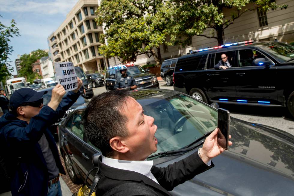 Protesters shout as the motorcade carrying Chinese Vice Premier Liu He and his delegation depar ...