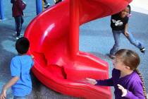 Students run around a broken slide in the playground at Helen Smith Elementary School in Las Ve ...