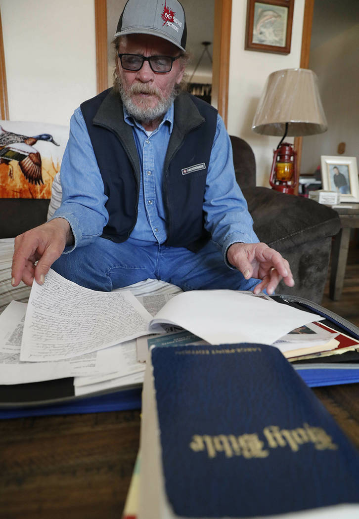 In this Friday, March 22, 2019 photo, Allan Votaw, 66, looks over his writings that describe th ...