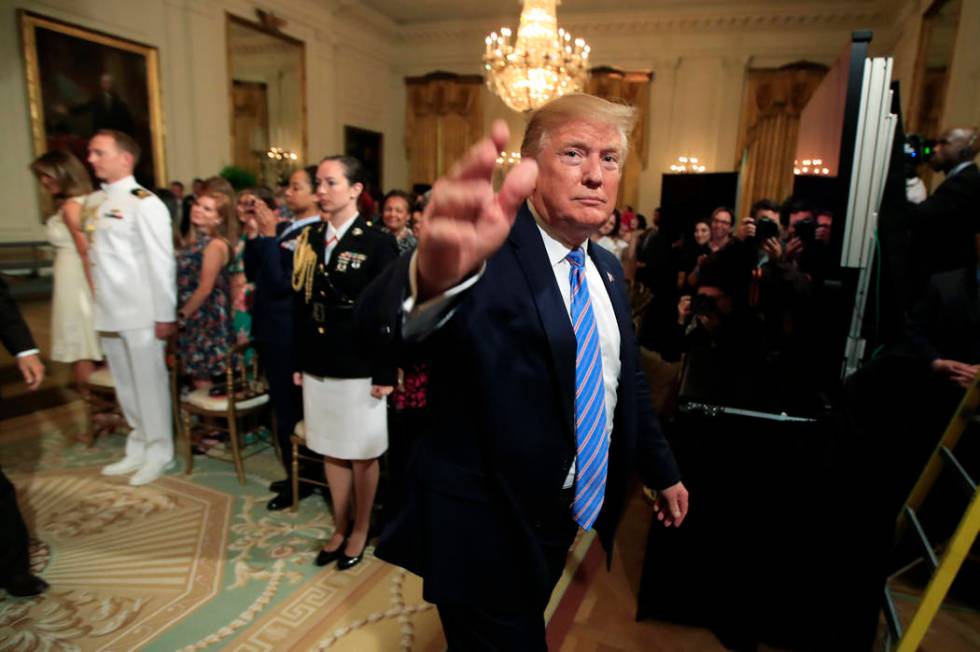 President Donald Trump waves as he leaves the East Room during a celebration of military mother ...