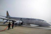 Firefighters work with hose on a plane of Myanmar National Airline (MNA) after an accident at M ...