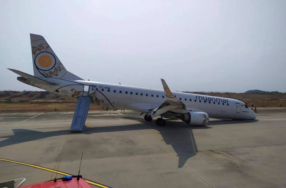 Rescue team gather near a plane of Myanmar National Airline (MNA) after an accident at Mandalay ...