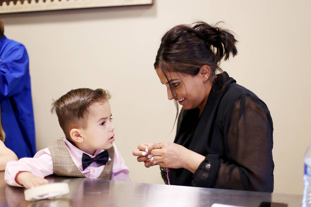 Noah Vidmar, 4, works on a friendship bracelet with his mom Natasha Vidmar at the Mother's Day ...