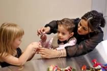 Noah Vidmar, 4, works on a friendship bracelet with his mom Natasha Vidmar and friend Penny Jon ...