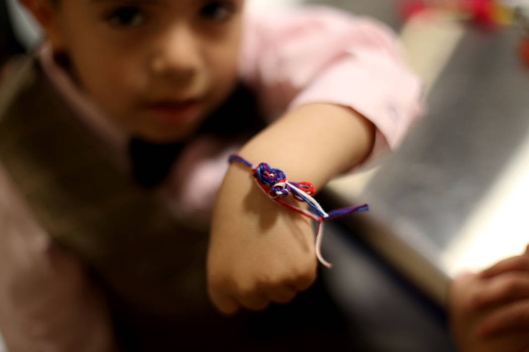 Noah Vidmar, 4, shows off his friendship bracelet at the Mother's Day Morning of Cookies & ...