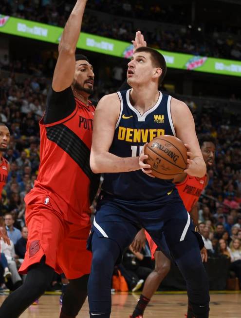 Denver Nuggets center Nikola Jokic, right, goes up for a basket Portland Trail Blazers center E ...