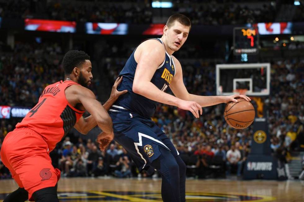 Denver Nuggets center Nikola Jokic, right, works the ball inside to the rim as Portland Trail B ...