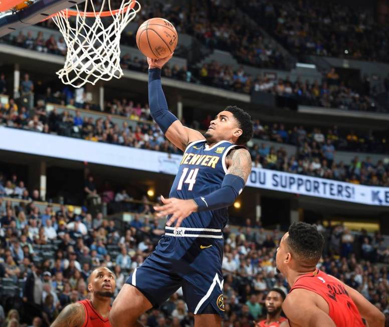 Denver Nuggets guard Gary Harris, center, goes up for a basket between Portland Trail Blazers g ...