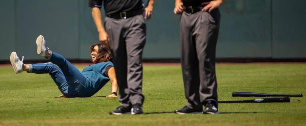 An Aviators fan falls down during a dizzy bat race with her daughter during a break in the acti ...