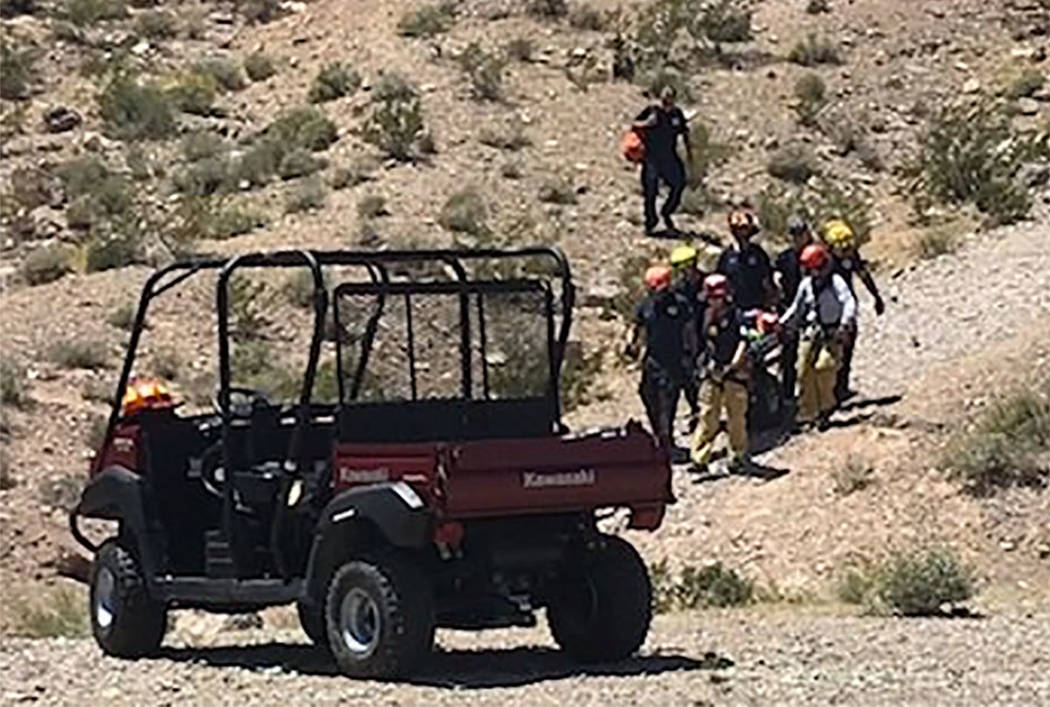 Rescuers carry a sick hiker down Lone Mountain in Las Vegas on Sunday, May 12, 2019. (Las Vegas ...