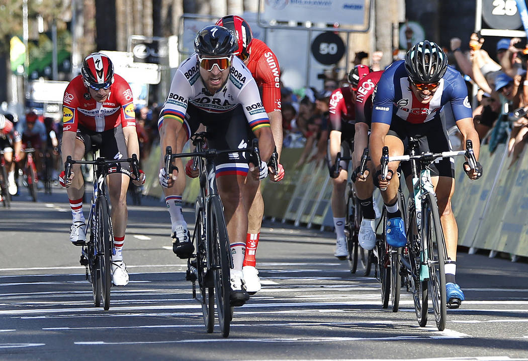 Peter Sagan, of the Bora-hansgrohe team, second from left, crosses the finish line ahead Travis ...