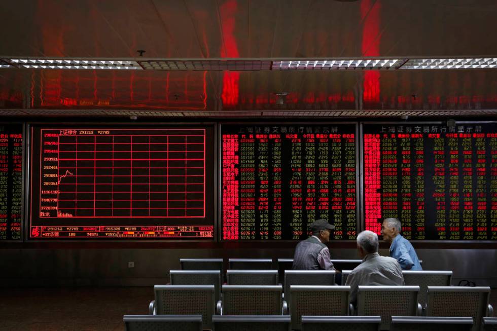 Chinese investors chat as they monitor stock prices at a brokerage house in Beijing, Monday, Ma ...