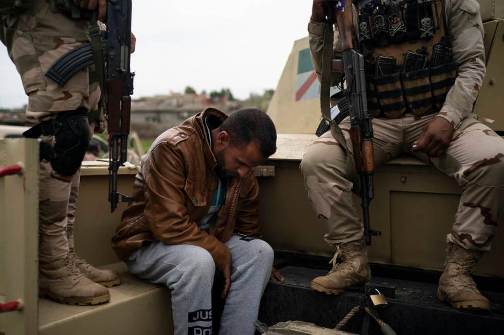 In this April 5, 2019 photo, a man is taken for questioning by Iraqi army 20th division soldier ...