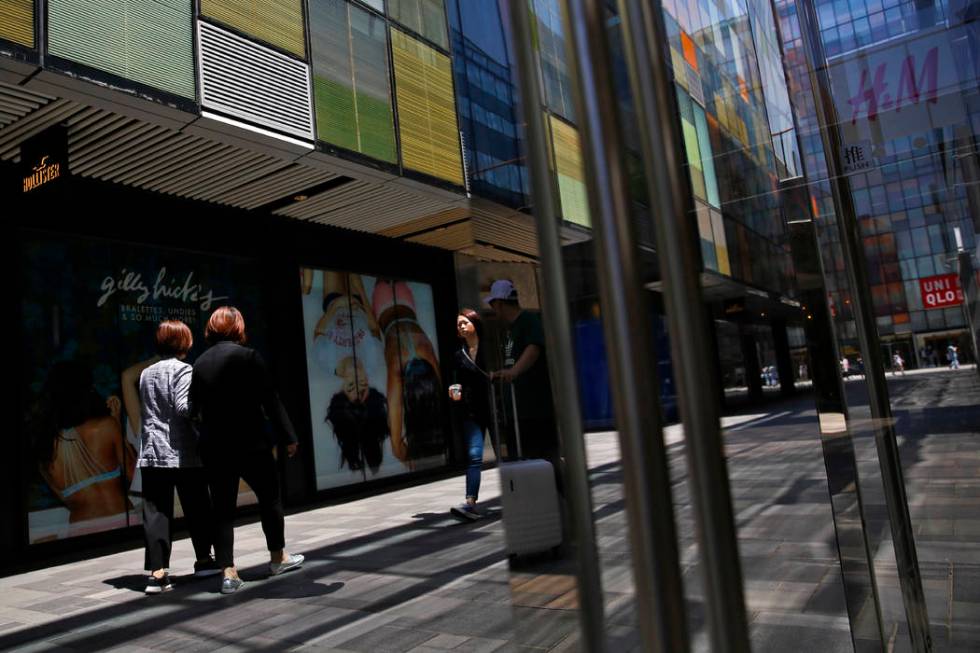 Shoppers walk by foreign fashion boutiques at the capital city's popular shopping mall in Beiji ...