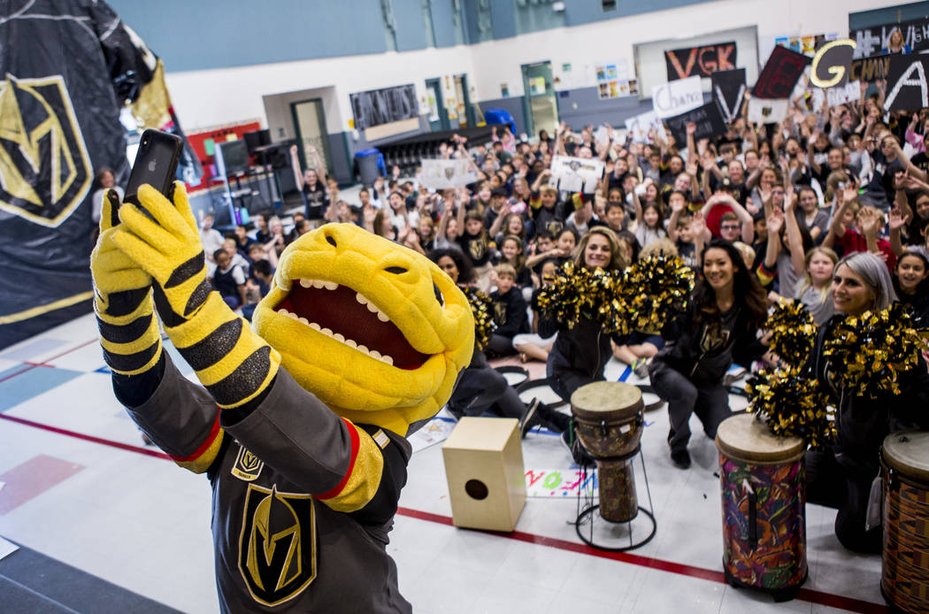 Vegas Golden Knights mascot Chance the Gila monster takes a selfie with the crowd during a Gold ...