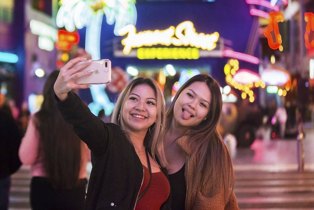 Camile Sangalang, left, and Jasmine Hsiao, both from Vancouver, British Columbia, take a selfie ...