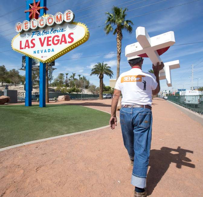 Greg Zanis, of Aurora, Ill., carries one of 58 crosses he placed near the "Welcome to Fabulous ...