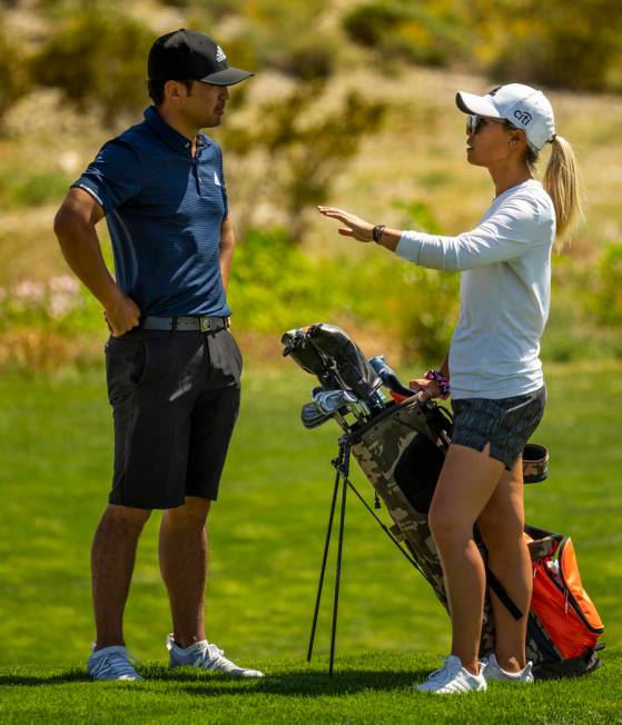 Golfer Alexander Kang listens to his sister and caddy LPGA golfer Danielle Kang on the course d ...