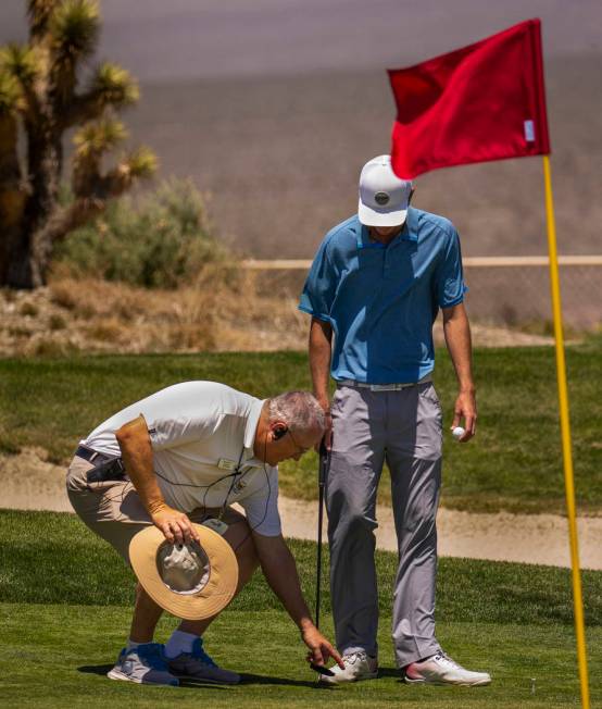 Time Quinn with the rules team instructs golfer Van Thomas on ball placement as his was in a di ...