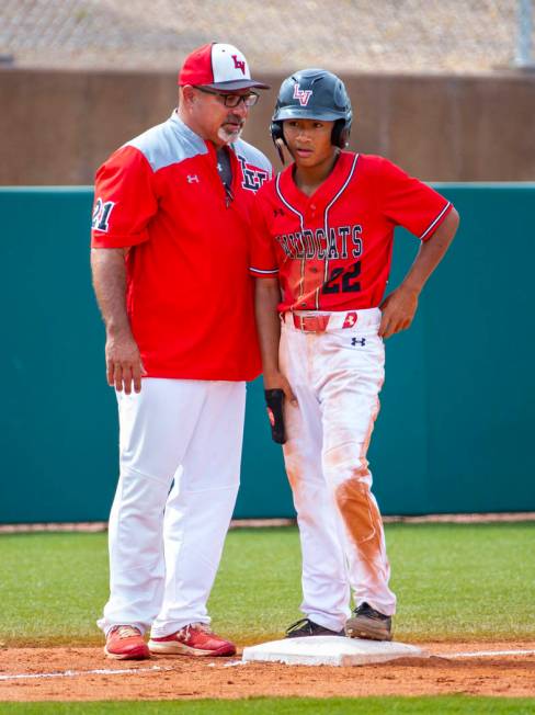 Longtime Las Vegas High coach Sam Thomas instructs runner Layne Adaro (22) at third base during ...