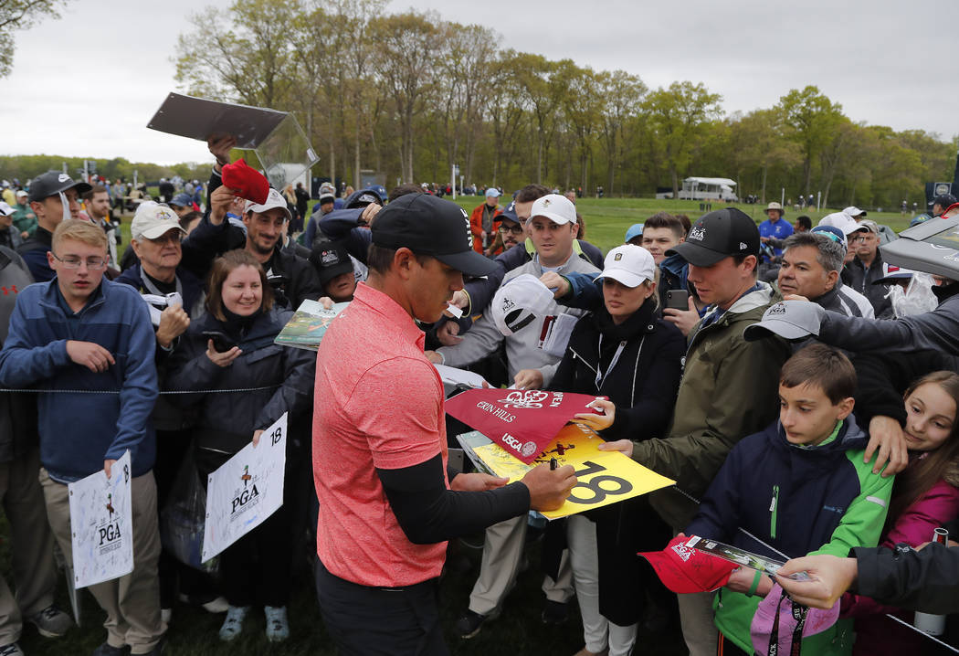 Brooks Koepka signs autographs for fans after a practice round at the PGA Championship golf tou ...