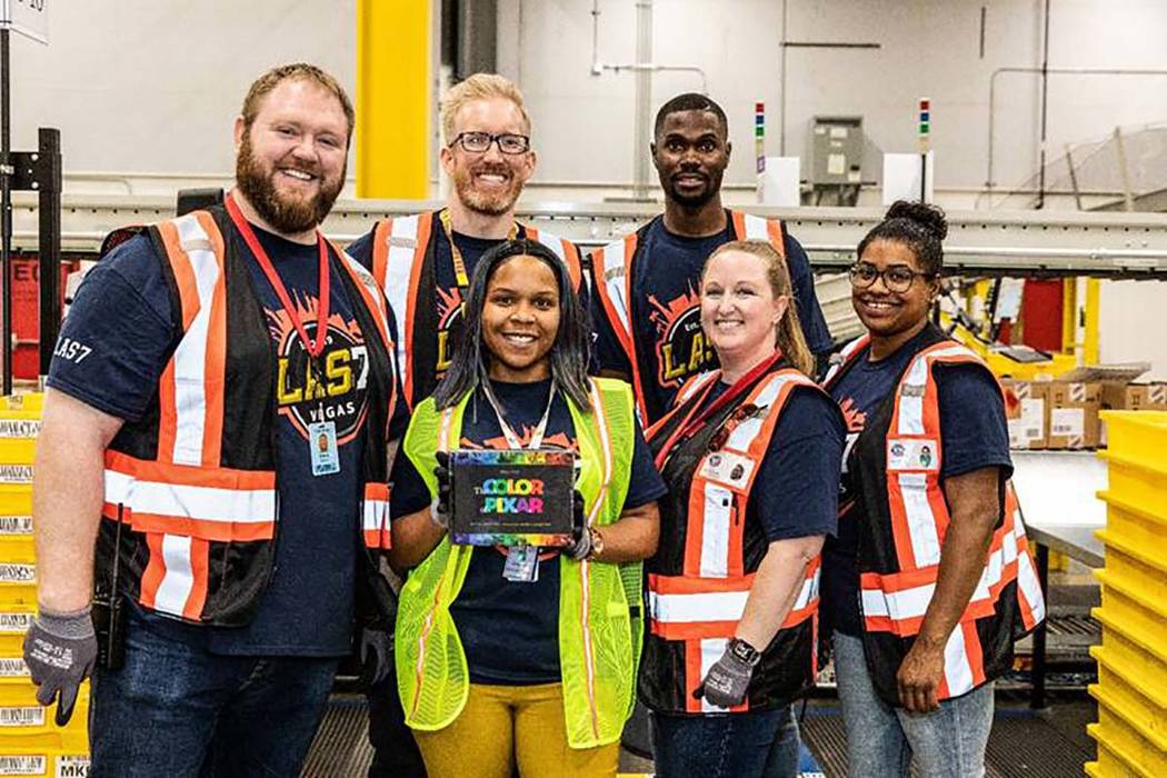 Amazon team members show off the first item received into the new North Las Vegas facility: a h ...