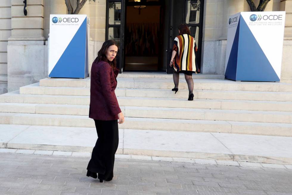 New Zealand Prime Minister Jacinda Ardern, left, leaves after a press conference, at the OECD h ...