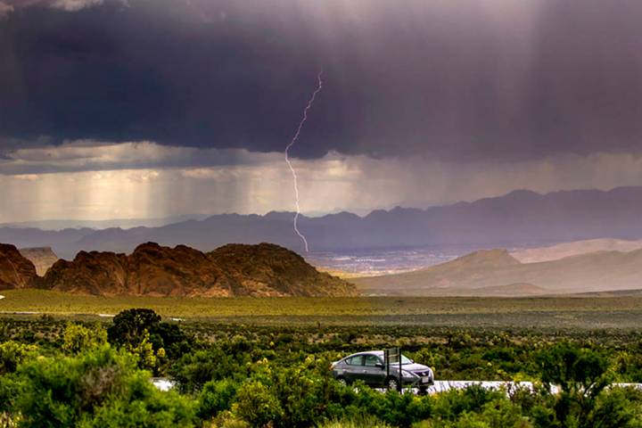 A lightning bolt streaks down as a fast-moving storm makes its way through the Red Rock Canyon ...