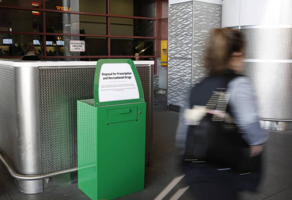 A passenger walks past a recently installed marijuana amnesty drop box at McCarran Internationa ...