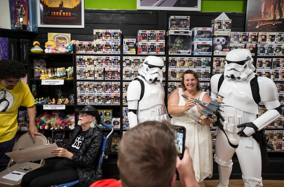 Colin Cantwell, left, concept artist and model builder for the original Star Wars movies, signs ...