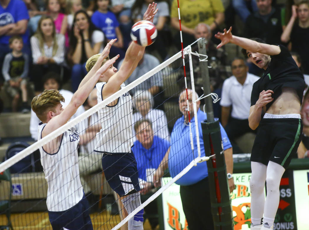 Palo Verde's Scott Solan (1) spikes the ball past Coronado's Ethan Hansen, left, and Jacob Ceci ...