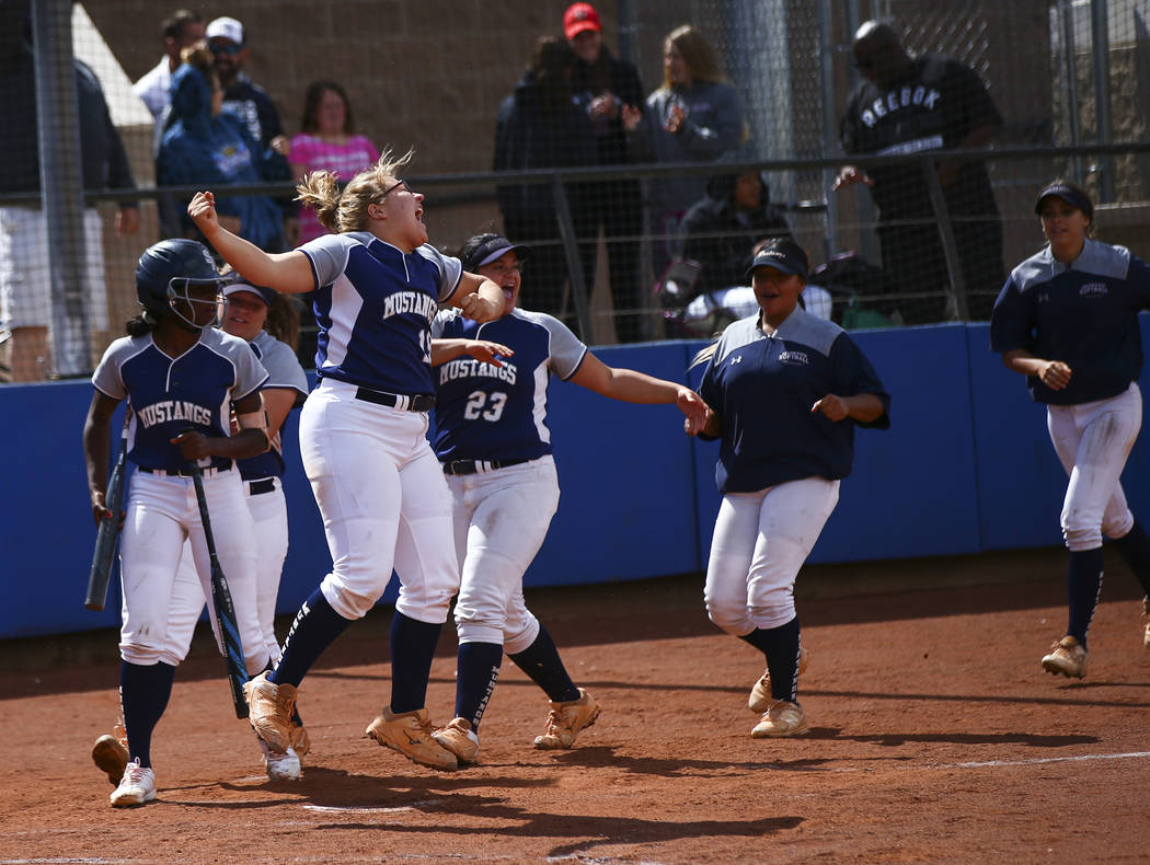 Shadow Ridge players celebrate a home run by Caitlin Covington, not pictured, during the second ...