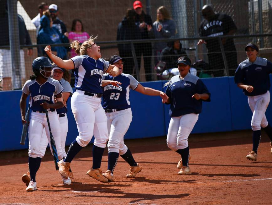 Shadow Ridge players celebrate a home run by Caitlin Covington, not pictured, during the second ...